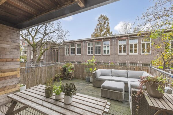 Cozy rooftop terrace with seating and plants.