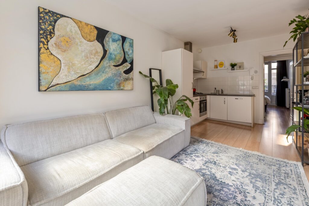 Modern living room with kitchen and abstract painting.