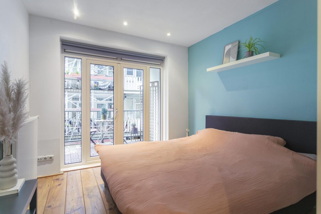Cozy bedroom with a balcony and plant decor.