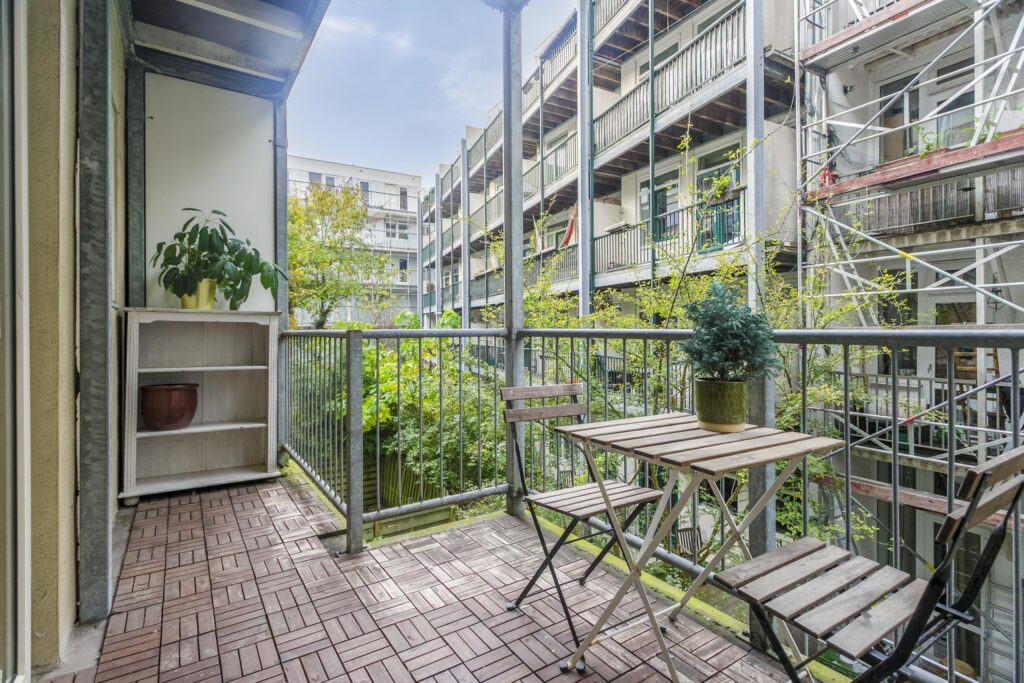 Cozy balcony with table and chairs, plant view.