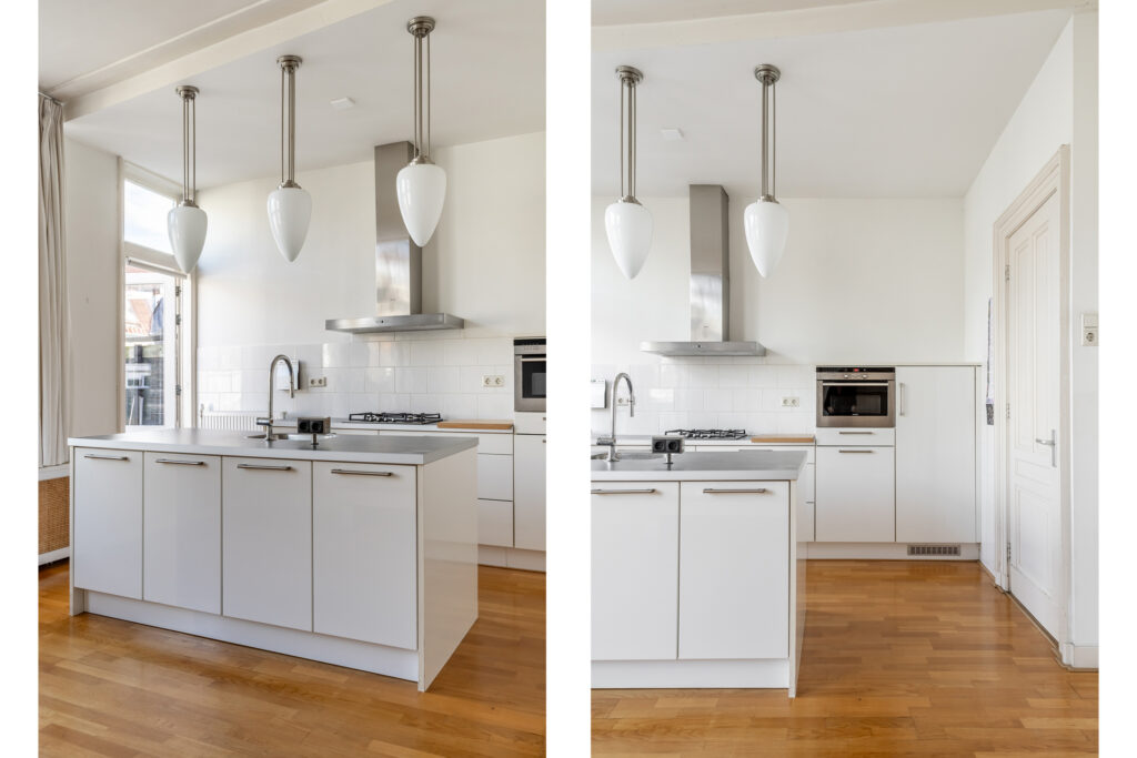 Modern white kitchen with island and pendant lights.