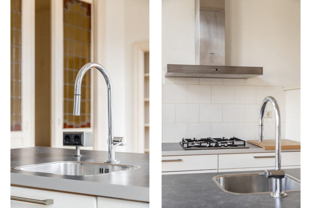Modern kitchen sink and stove with stainless steel fixtures.