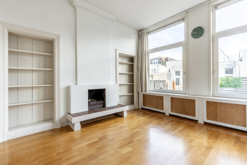 Bright living room with fireplace and wooden floors.