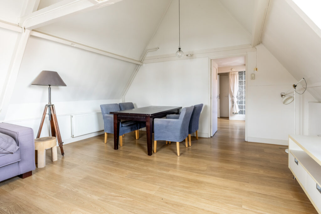 Bright attic dining room with wooden floors.