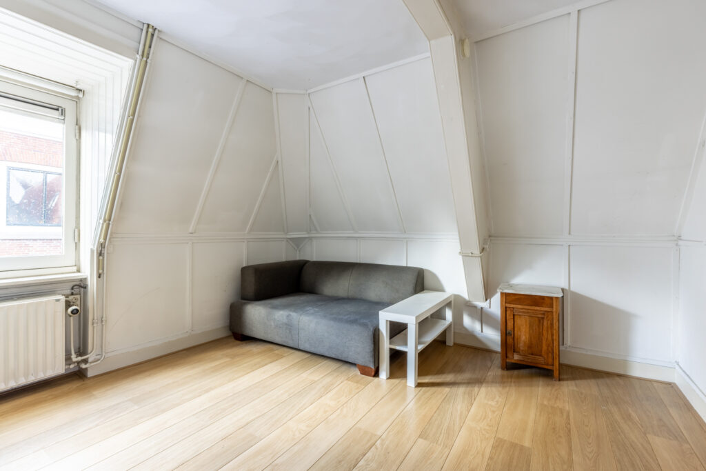 Small attic room with couch and side tables.
