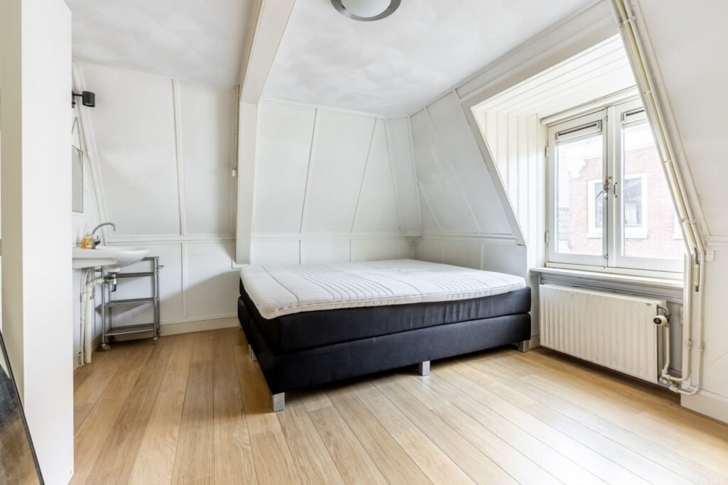 Cozy attic bedroom with bed and window