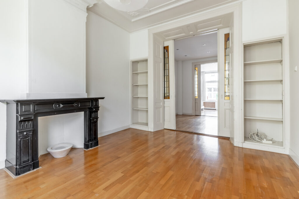 Spacious room with wooden floor and fireplace
