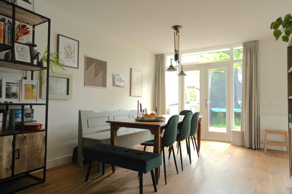 Cozy dining room with table and green chairs.