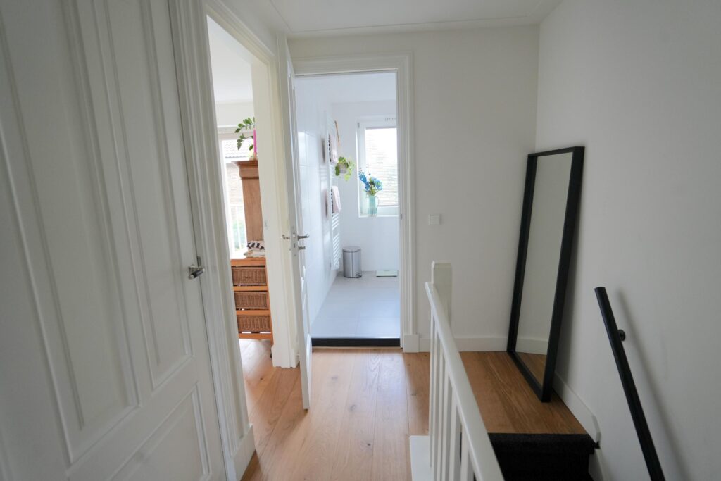 Bright hallway with open door and mirror.