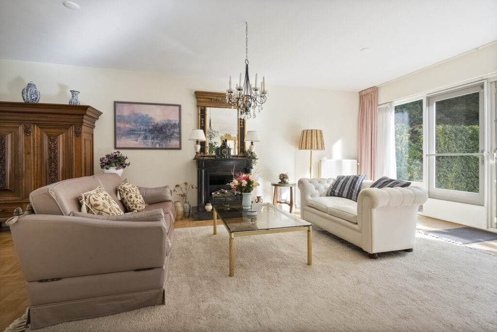 Elegant living room with chandelier and large windows.