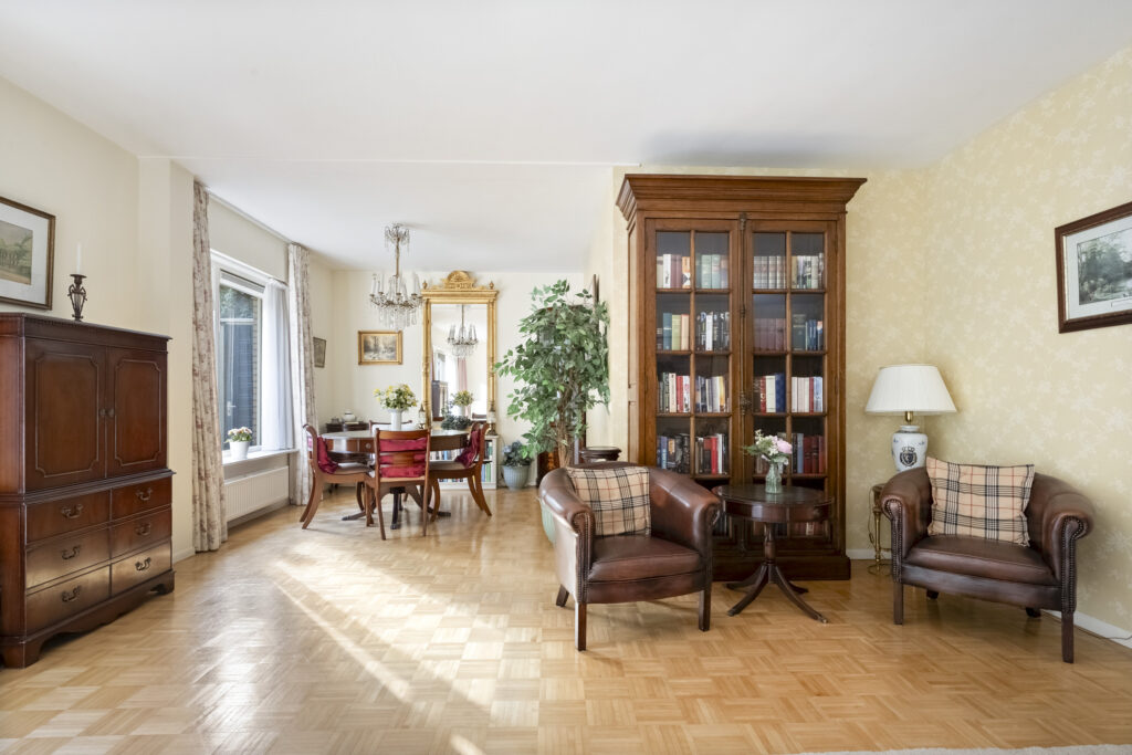 Elegant living room with classic furniture and bookshelves.