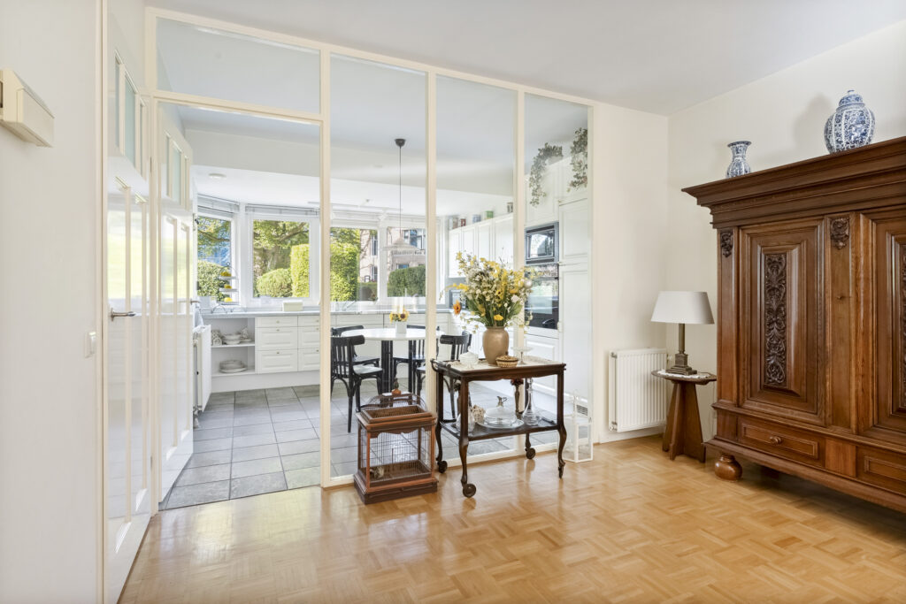 Bright kitchen with wooden furniture and glass divider.