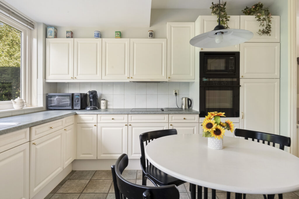 Bright kitchen with white cabinets and sunflowers.