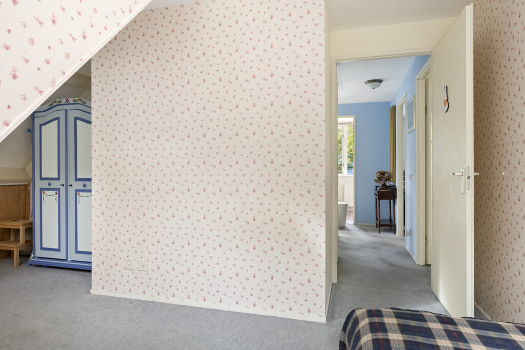 Cozy room with floral wallpaper and hallway view.