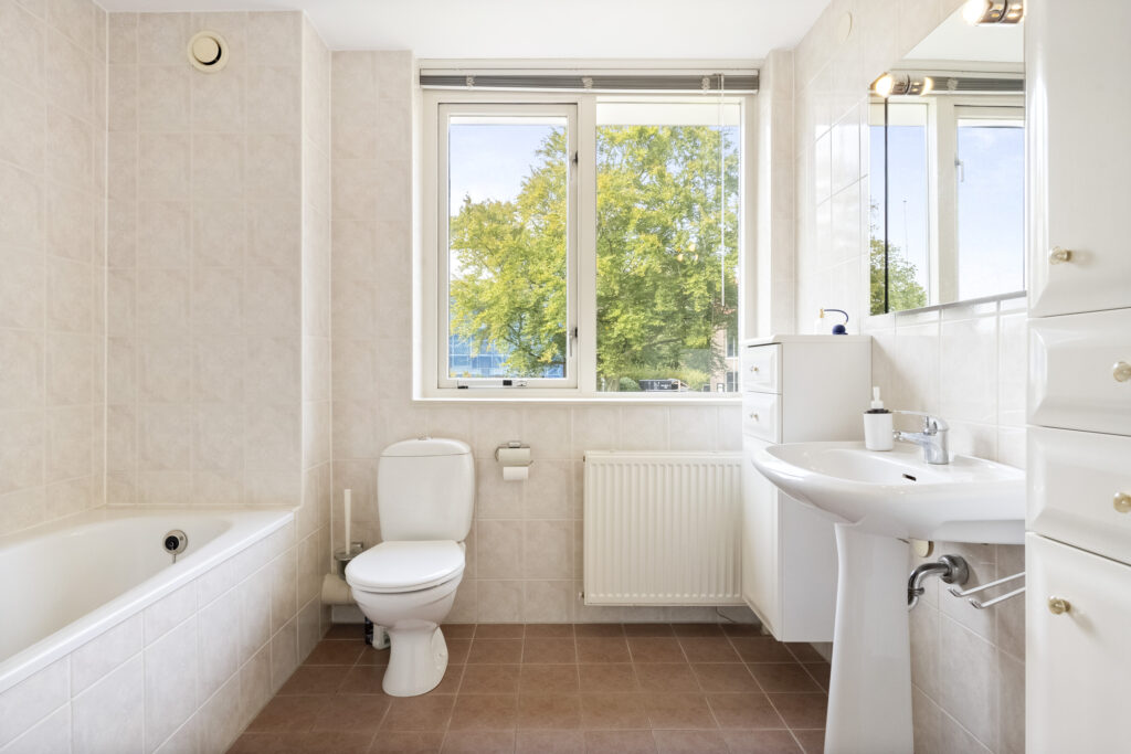 Modern bathroom with bathtub, toilet, and sink.