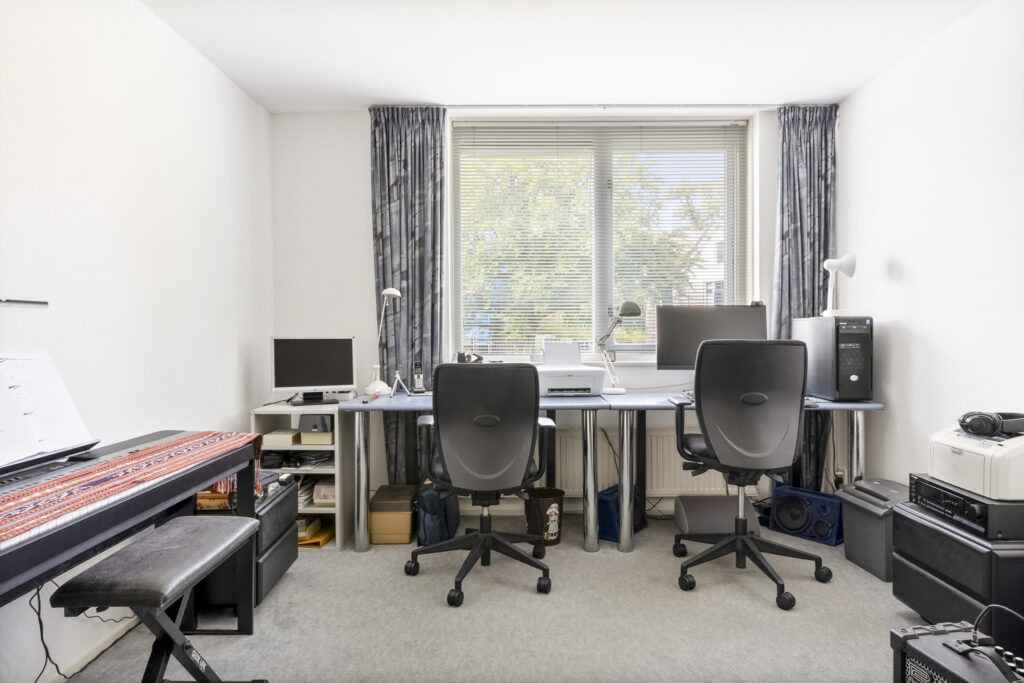 Home office with desks, chairs, and computers.