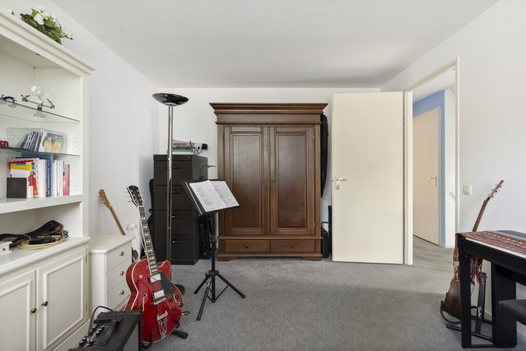 Music room with guitars and sheet music stand.