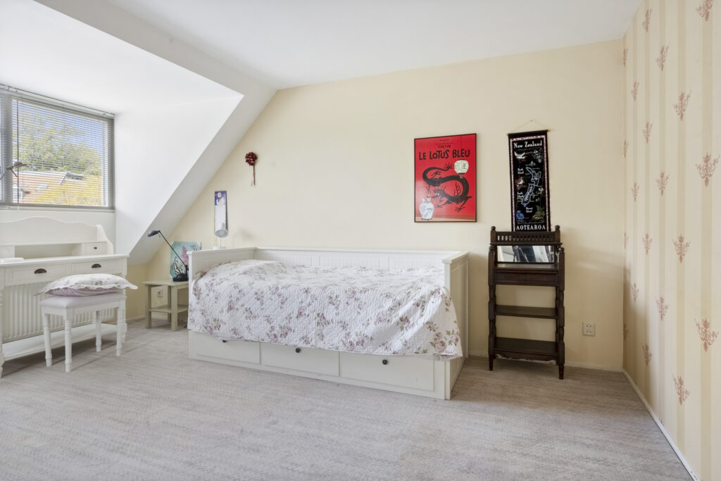 Cozy bedroom with poster and desk furniture.
