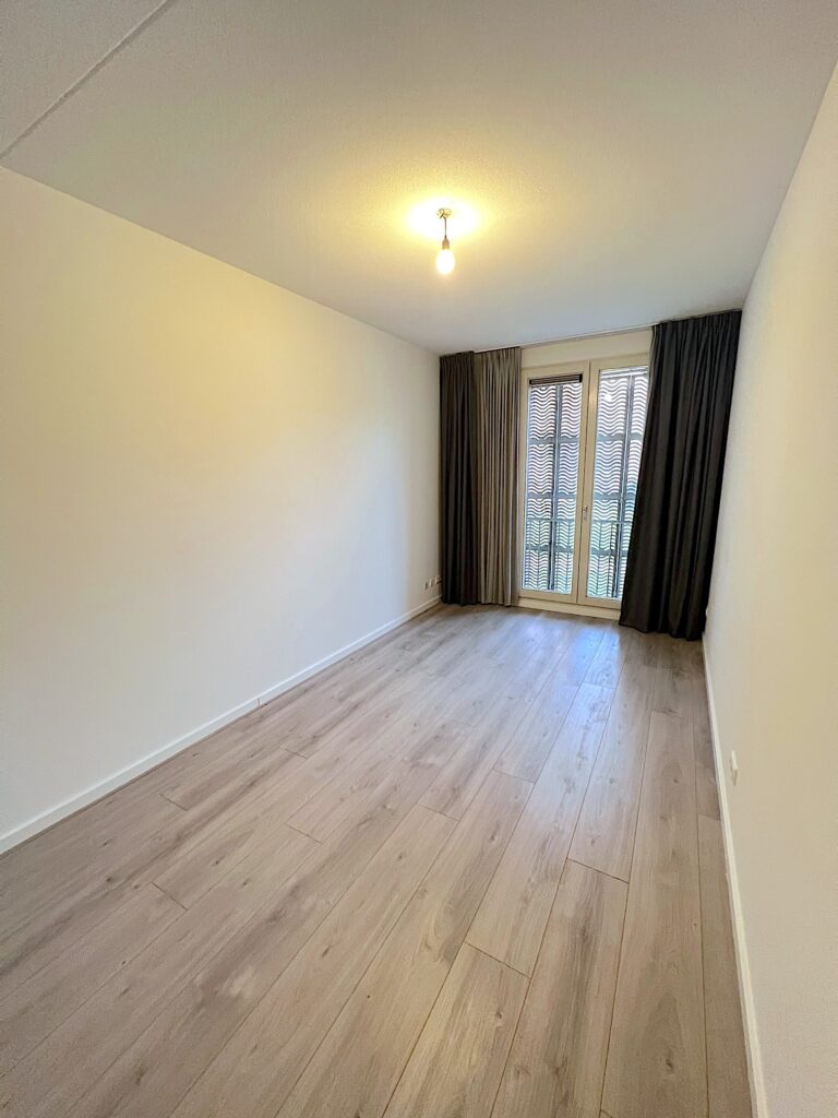 Empty room with wooden floor and curtains