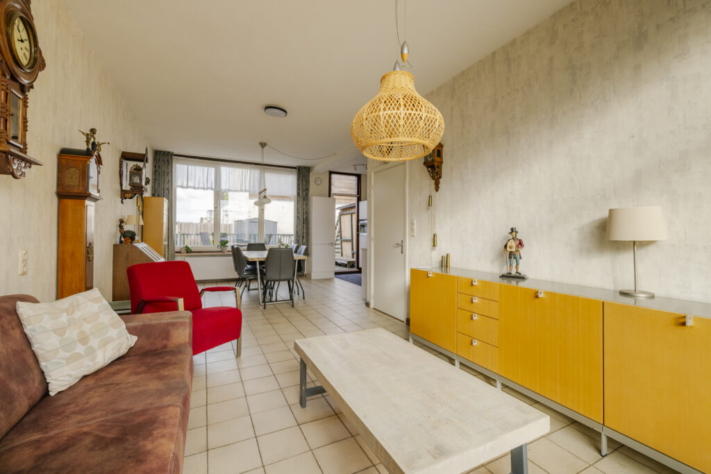 Modern living room with yellow cabinets and red chair.
