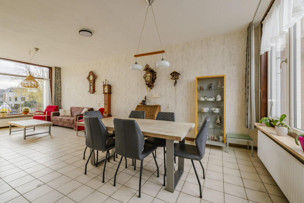 Spacious living room with dining table and clocks.