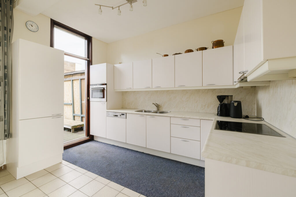 Modern kitchen with white cabinets and appliances.