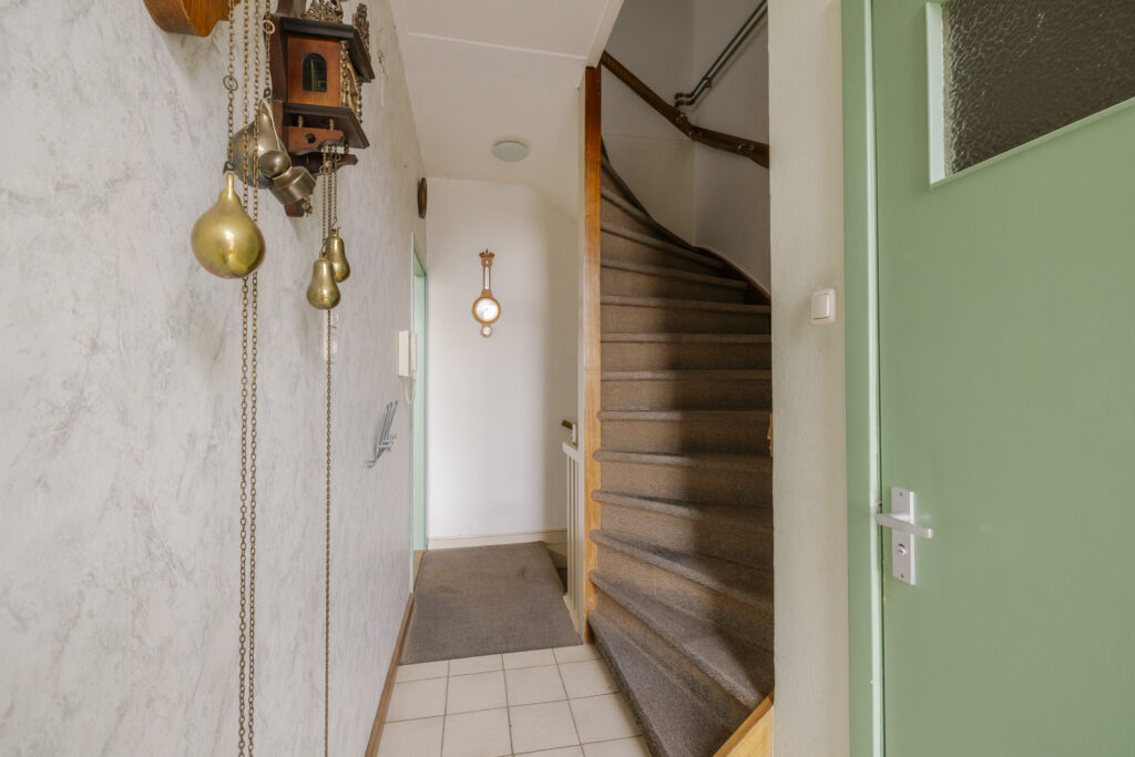 Cozy hallway with vintage clock and staircase.