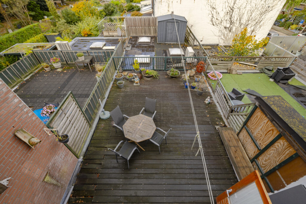 Rooftop patio with wooden table and chairs.