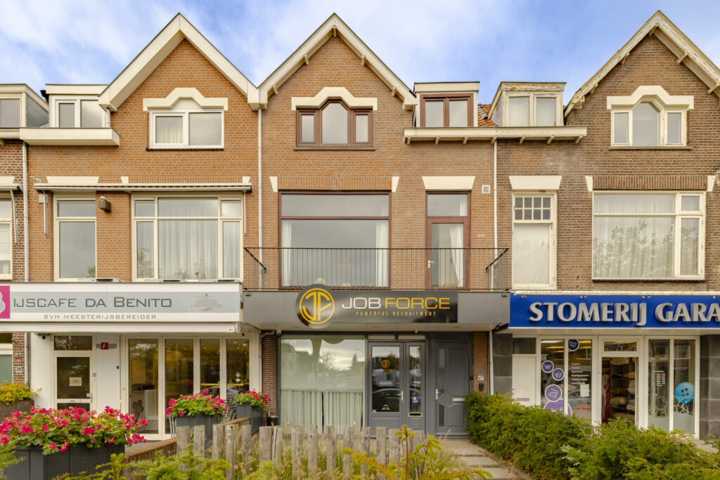 Brick building with stores and colorful signage.