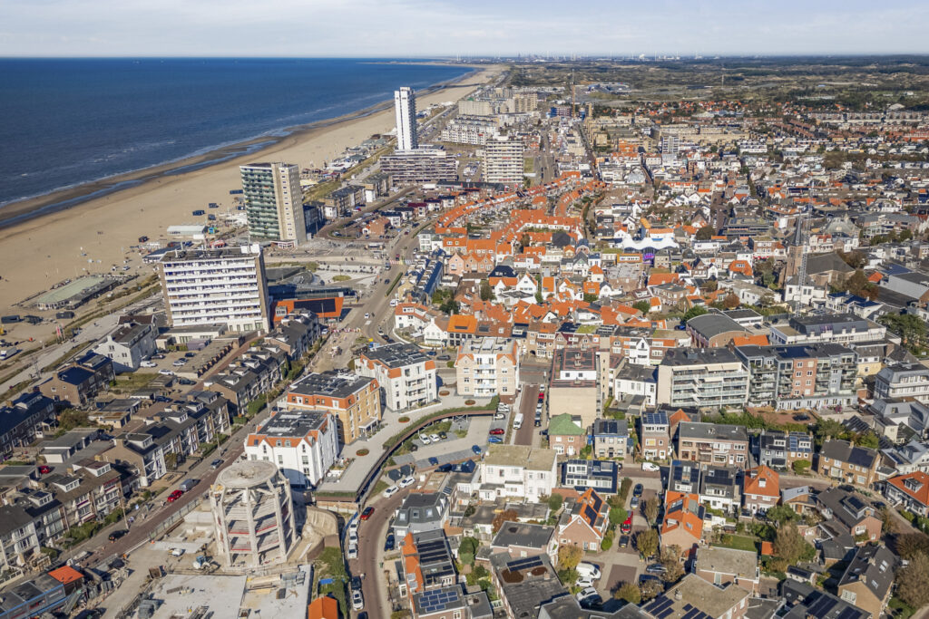 Aerial view of coastal city with beach and buildings.
