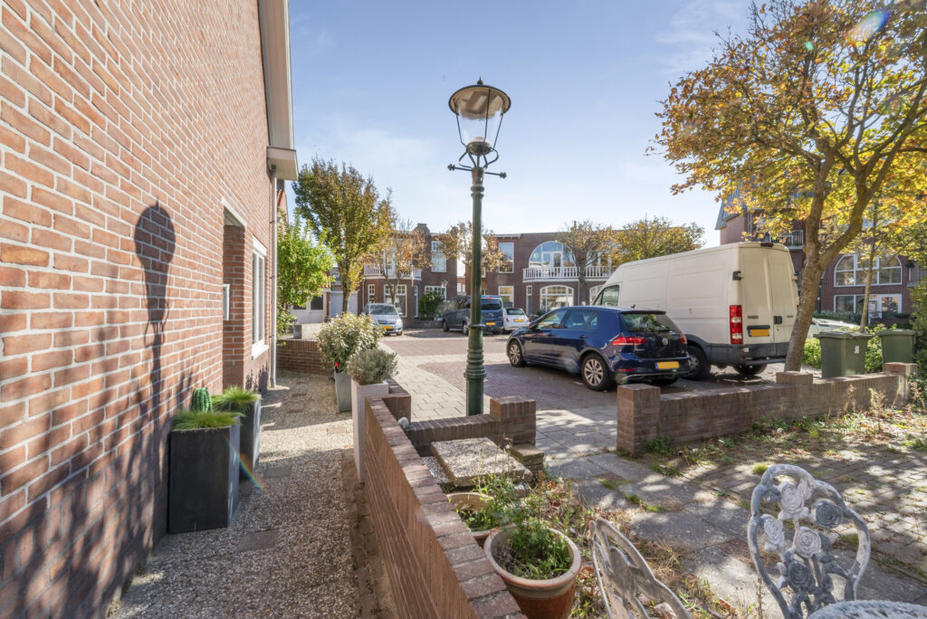 Residential street with parked vehicles and houses.
