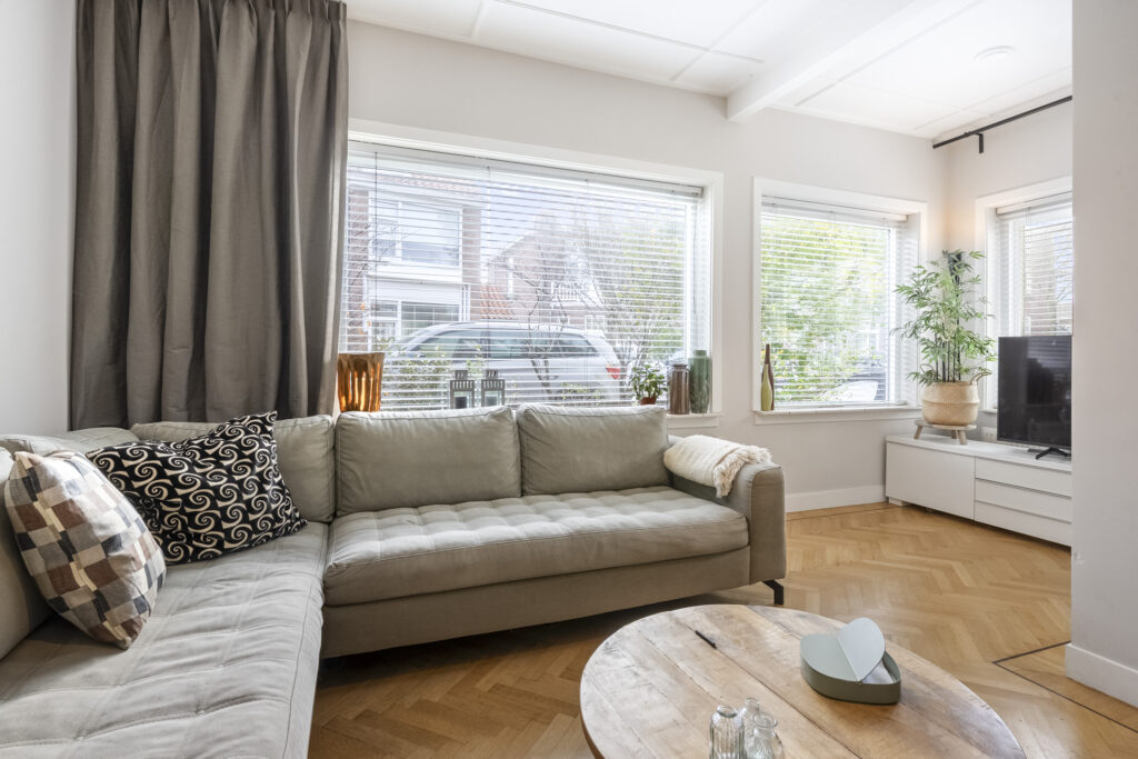 Modern living room with large windows and sectional sofa.