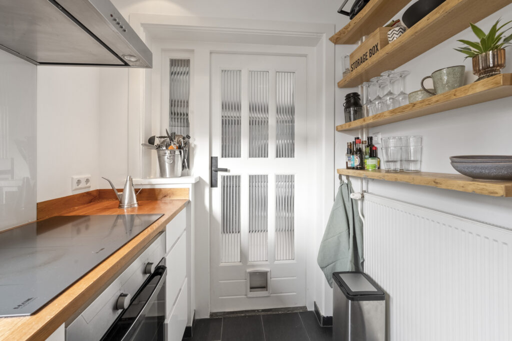 Small kitchen with modern shelves and appliances.