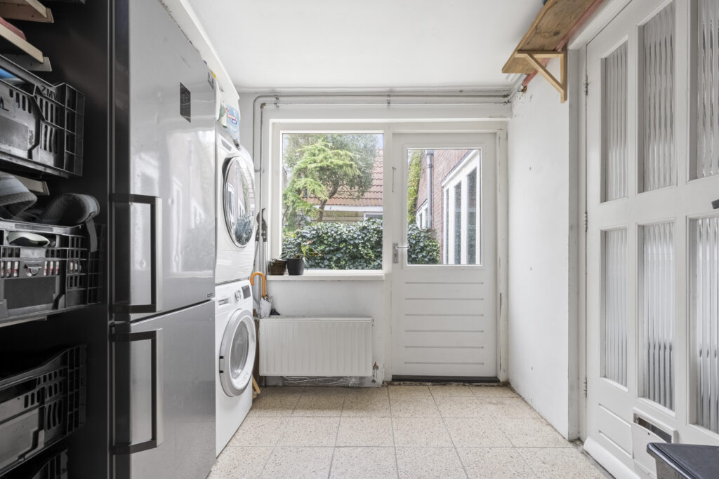 Laundry room with machines and garden view