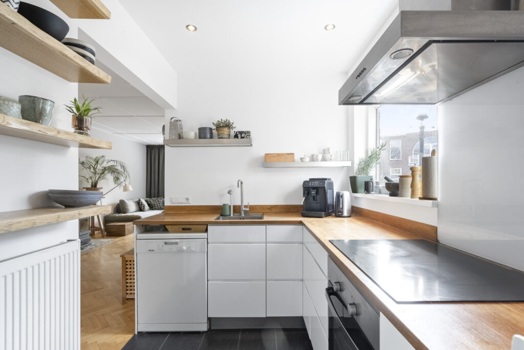 Modern kitchen with white cabinets and wood countertops.