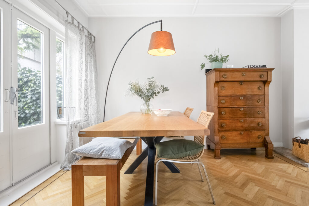 Cozy dining room with wooden table and vintage dresser.