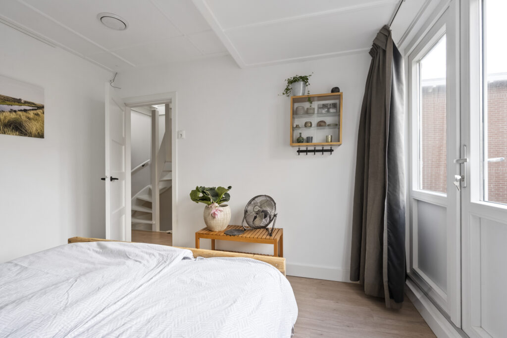 Cozy bedroom with plants and natural light.
