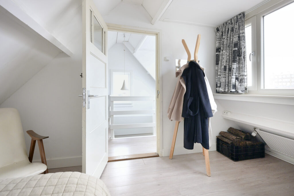 Minimalist room with wooden coat rack and chair