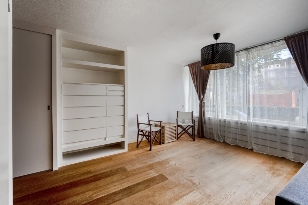 Minimalist room with wooden floor and white shelves.