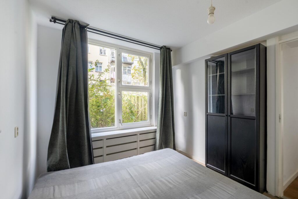 Bright bedroom with large window and curtains