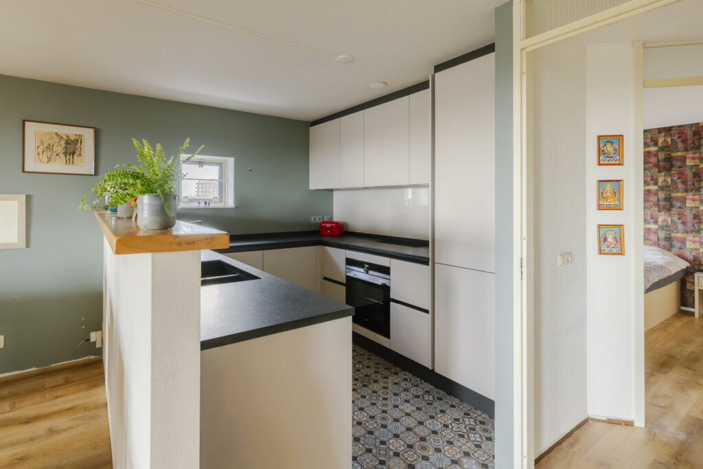 Modern kitchen with sleek cabinets and patterned floor.