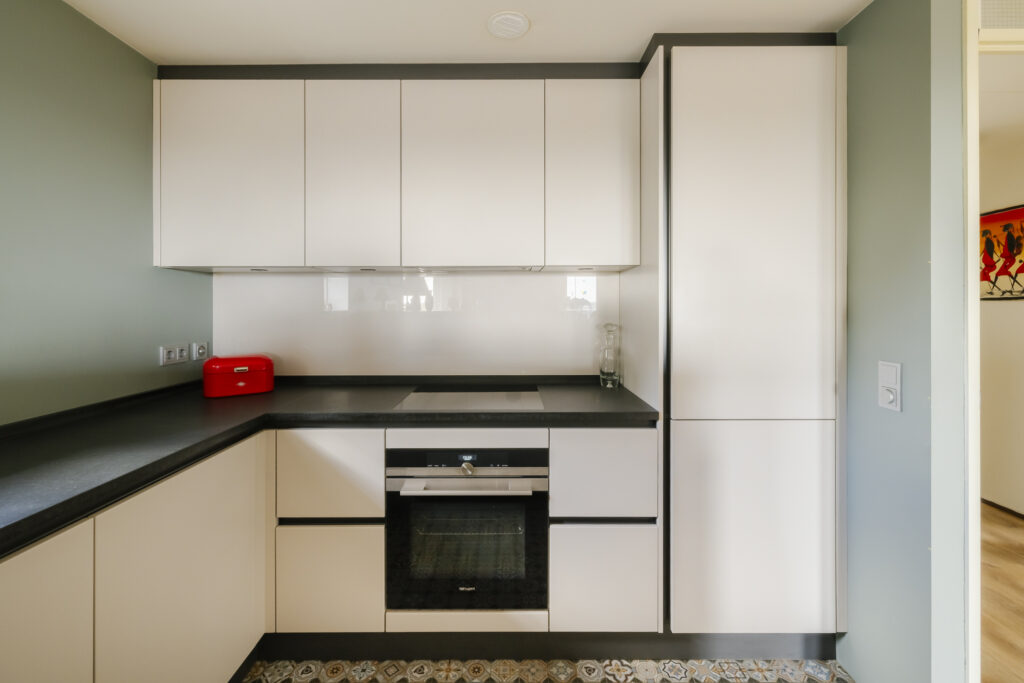 Modern kitchen with white cabinets and red toaster.