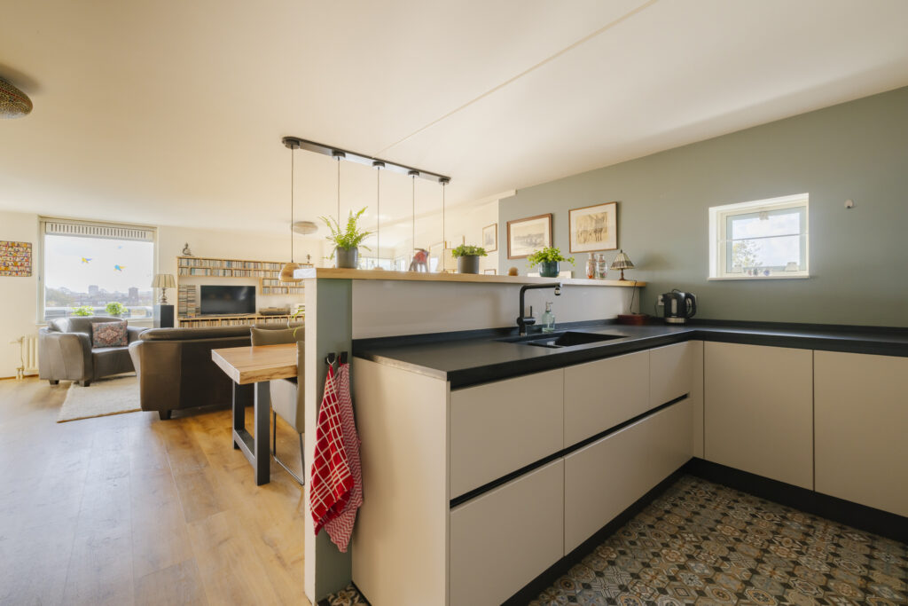 Modern kitchen and living area with green accents.