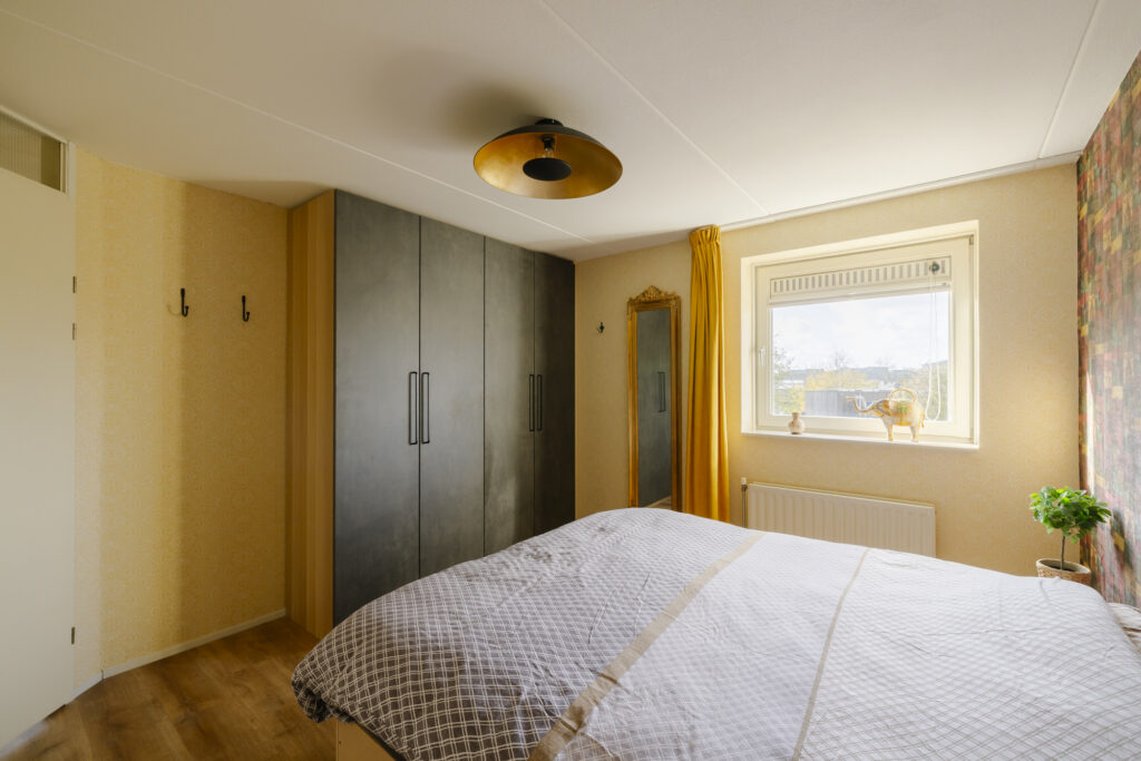 Cozy bedroom with large closet and window view.