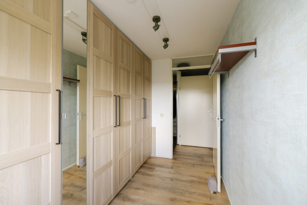 Modern walk-in closet with wooden wardrobes.