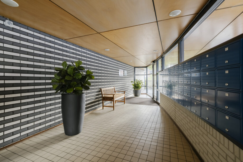 Lobby with mailboxes, plants, and a bench.