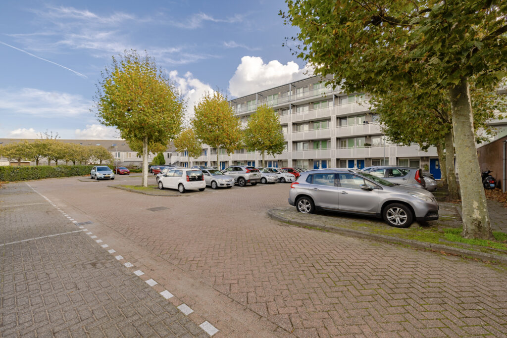 Apartment building with parked cars and trees