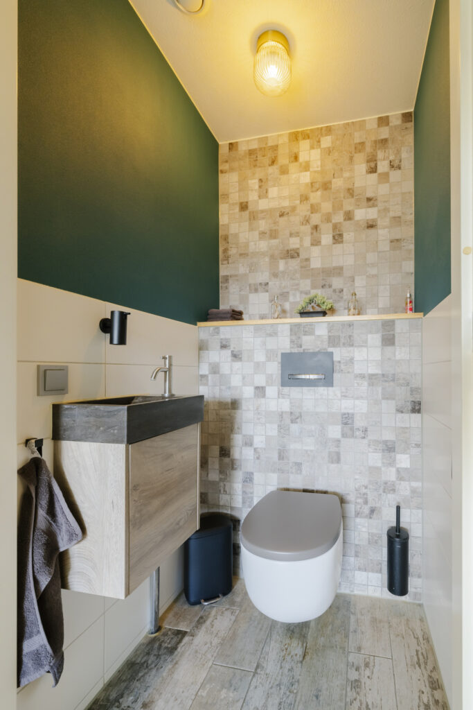 Modern bathroom with sink and wall-mounted toilet.