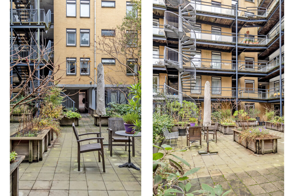 Urban courtyard with patio seating and spiral staircase.