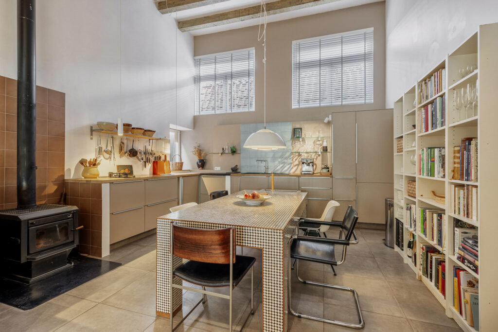 Modern kitchen with dining table and bookshelves.